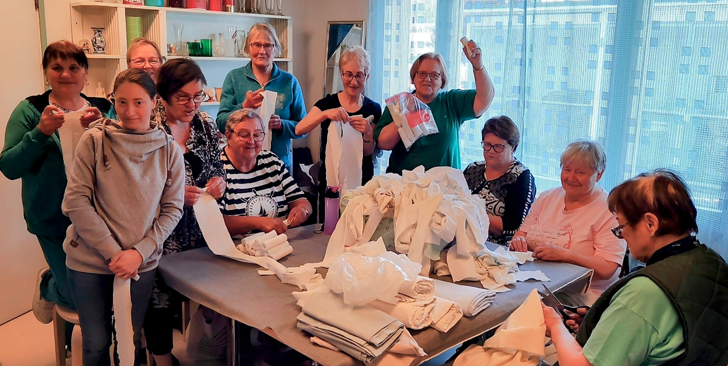 Ukrainalaisia ja vihtiläisiä kinnaslaisia ahkeroimassa vanhoista lakanoista siderullia sotilaille. Humanitaarinen toimintaryhmä Kinnas on jo kolmen vuoden ajan lähettänyt avustustavaraa Ukrainaan.